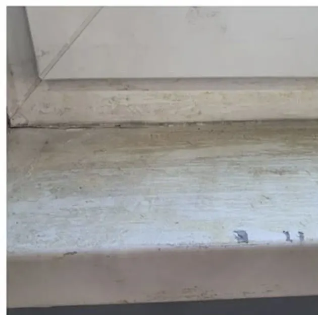 Verschmutzte Fensterbank mit Ablagerungen vor der Reinigung