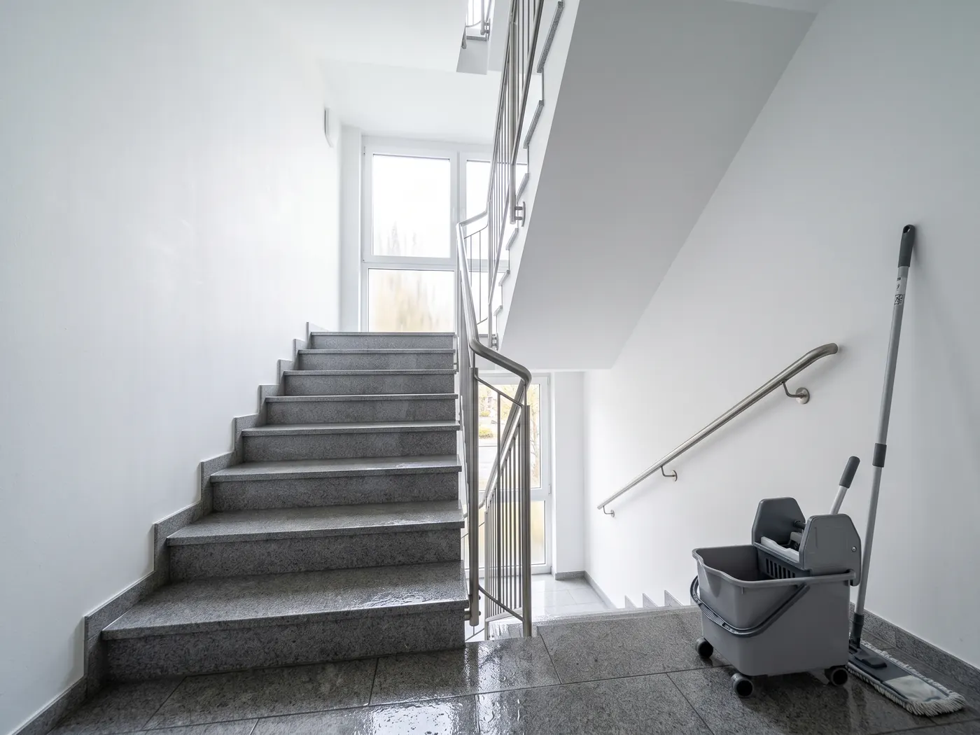 Frisch gewischtes Treppenhaus mit Eimer und Flachmopp in Hamburg